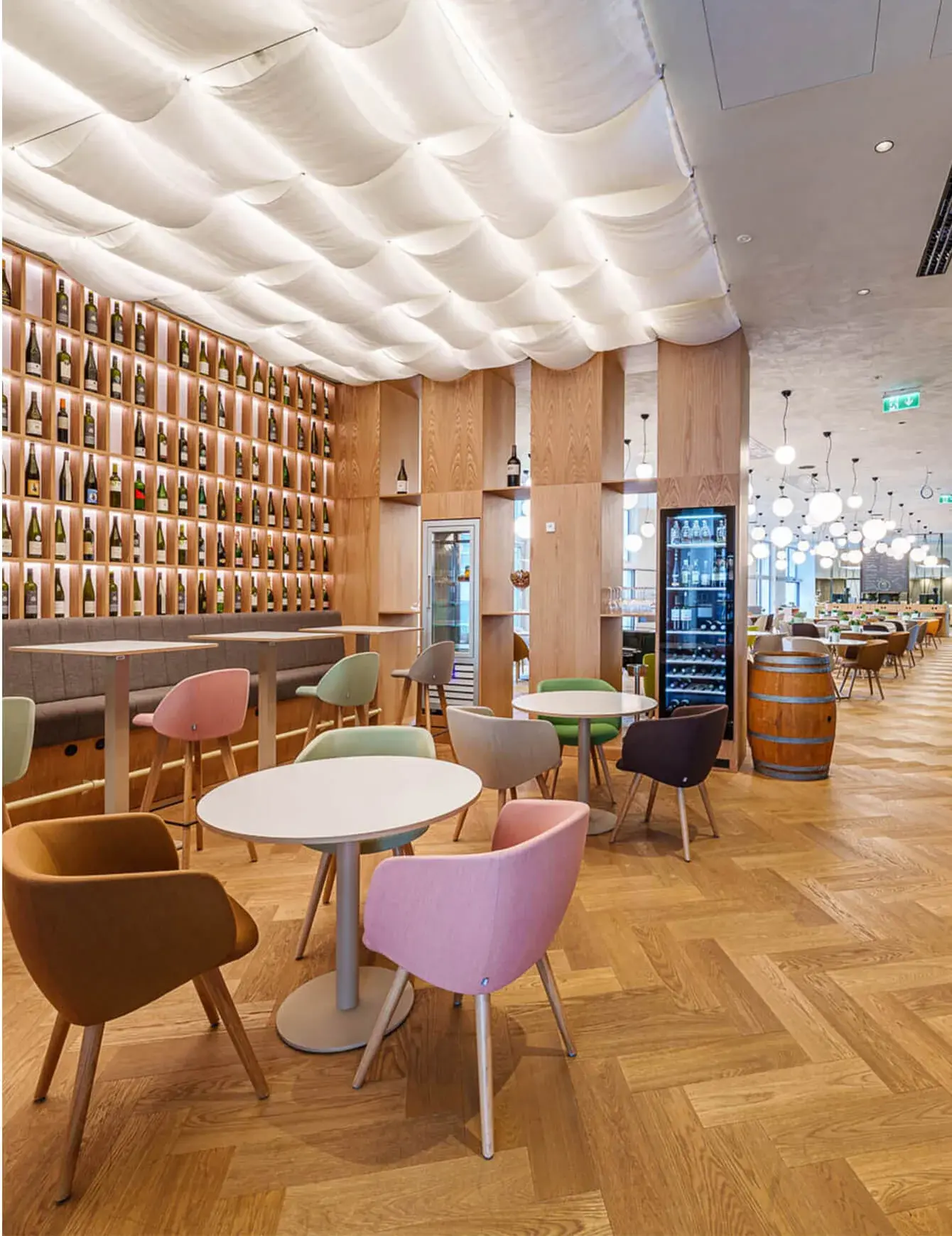 Moderní prosvětlené Hotelové lobby Holiday Inn s dubovou podlahou položenou do vzoru stromečku, které doplňuje barevný designový nábytek, prosklená vino