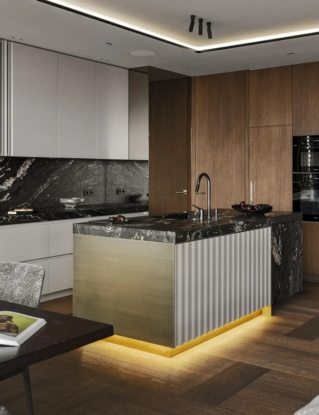 Moderní kuchyně v soukromém bytě ve Varšavě s tmavou dubovou podlahou Oakcent, kterou doplňuje luxusní mramorový ostrůvek s podsvíceným mosazným čelem a bílá minimalistická linka.