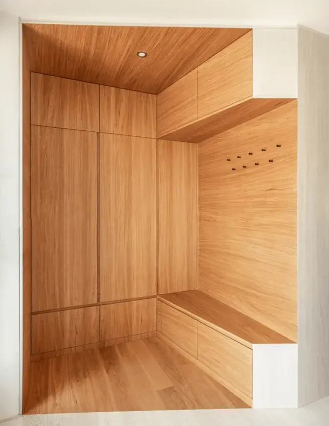 Moderní a prosvětlený interiér rodinného domu v Brně-Jundrově, kde designu dominuje precizní dřevěné obložení šatní stěny a předsíně v odstínu Honey plynule přecházející v dubovou podlahu Oakcent Ivory, čímž vzniká elegantní a ucelený prostor propojující vstupní část s obytnou zónou.