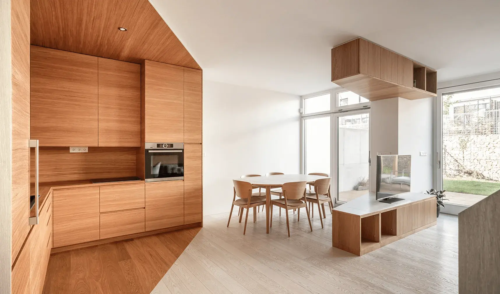 Moderní a prosvětlený interiér rodinného domu v Brně-Jundrově, kde designu dominuje precizní dřevěné obložení kuchyně v odstínu Honey plynule přecházející v dubovou podlahu Oakcent Ivory, čímž vzniká elegantní a ucelený prostor propojující kuchyň s jídelnou.