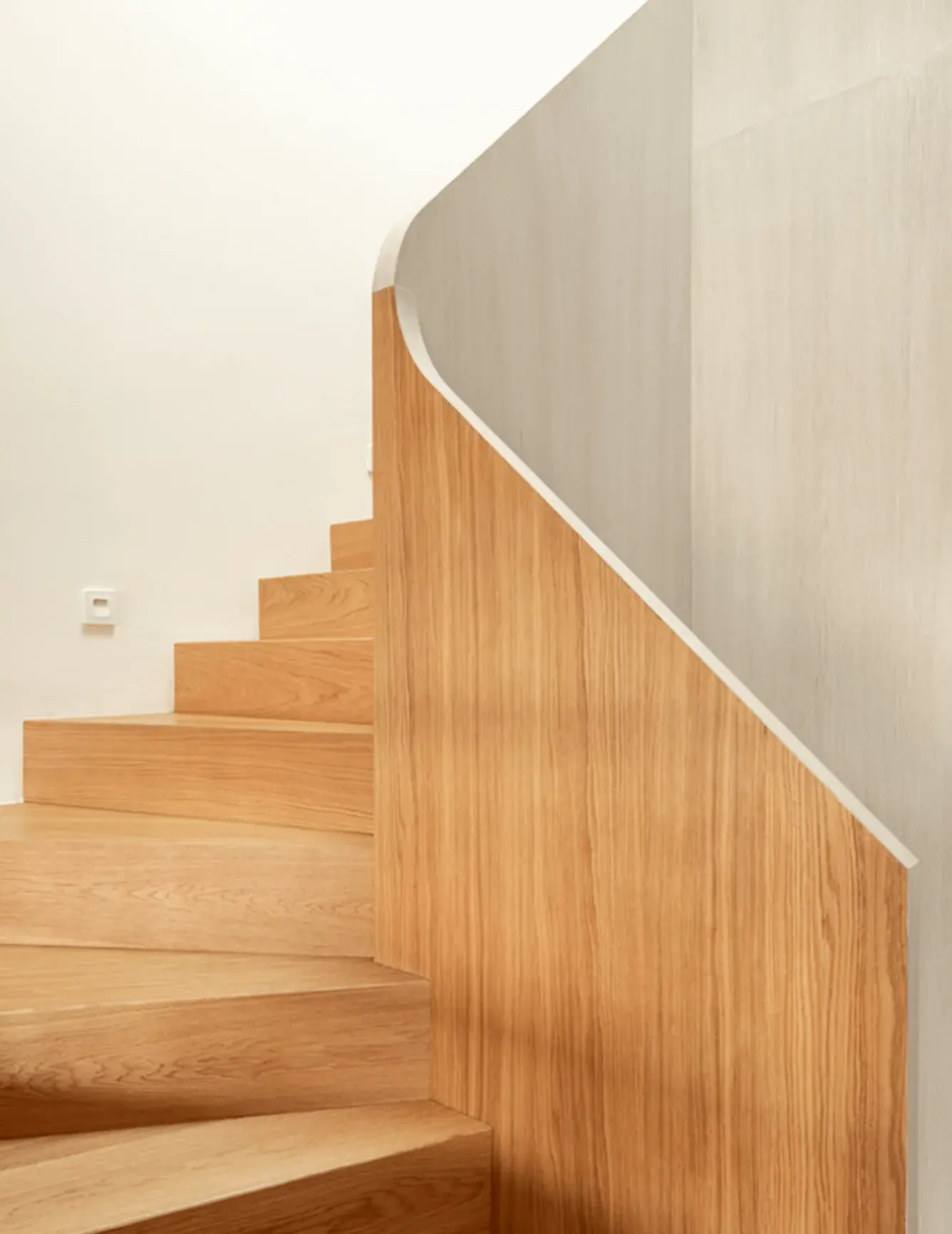 Moderní a prosvětlený interiér rodinného domu v Brně-Jundrově, kde designu dominuje precizní dřevěné obložení schodiště v odstínu Honey plynule přecházející v dubovou podlahu Oakcent Ivory, čímž vzniká elegantní a ucelený prostor propojující jednotlivá podlaží.