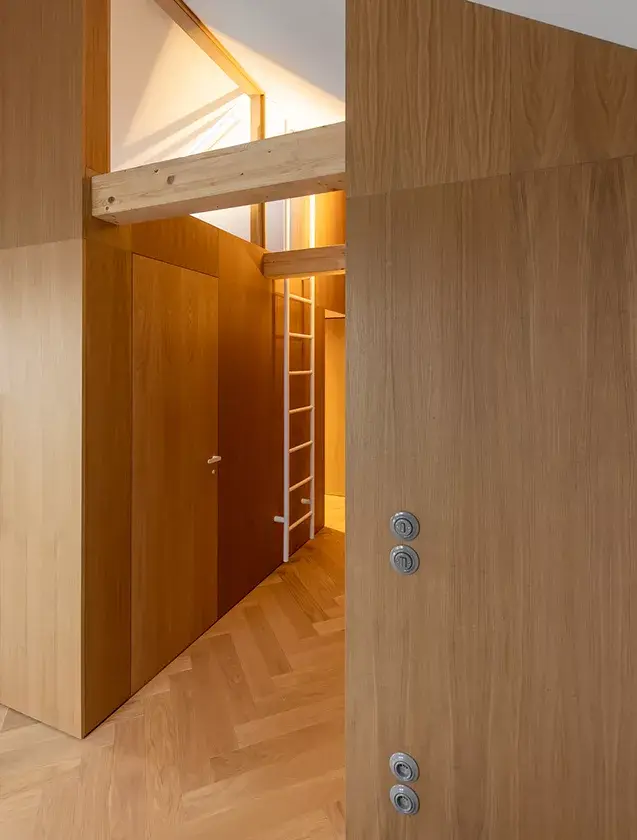 Alt: Detailní pohled na kartáčovanou dubovou podlahu Oakcent Premium se vzorem rybí kosti (Herringbone), ošetřenou přírodním olejem, která v olomouckém střešním bytě od Cojocarů Architekti zdůrazňuje přirozenou texturu dřeva s výrazným sukem.