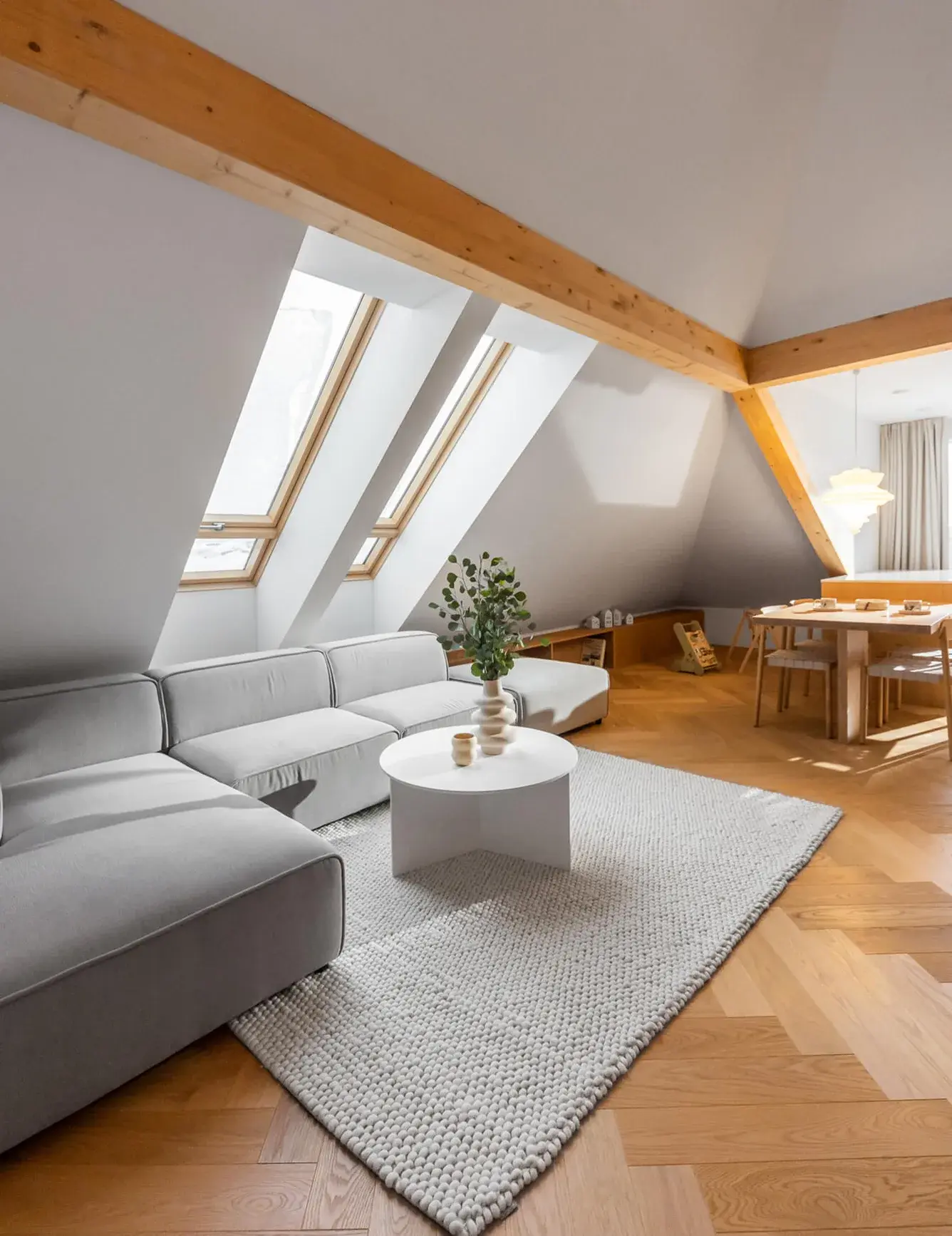 Detailní záběr na kartáčovanou dubovou podlahu Oakcent Premium se vzorem rybí kosti (Herringbone), ošetřenou přírodním olejem, která díky své medové barvě a přirozené textuře dřeva tvoří dominantní estetický prvek celého olomouckého bytu.