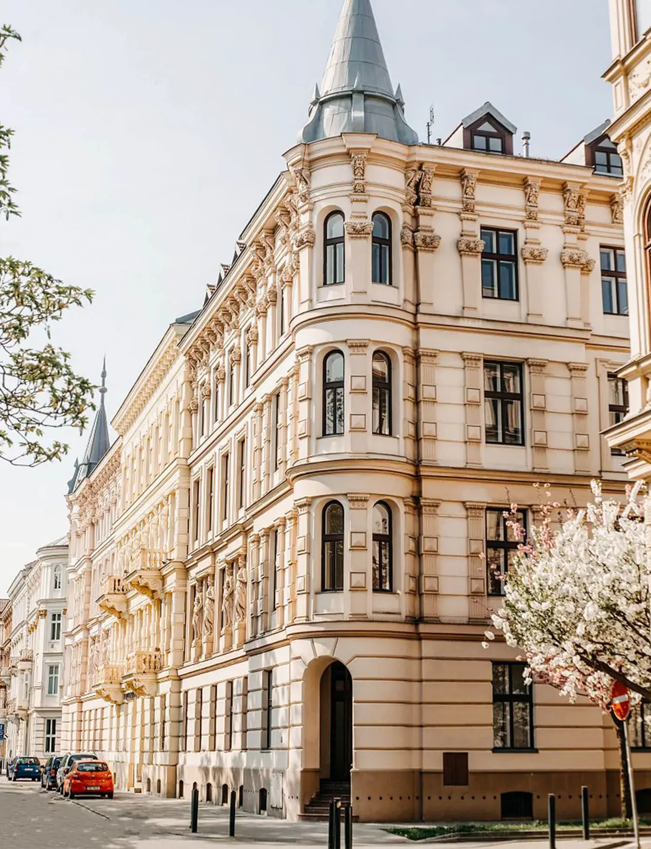 Exteriér historického nárožního činžovního domu v Brně s bohatě zdobenou fasádou, věžičkou a arkýři, kde proběhla realizace podlah Oakcent v rámci projektu studia A77 Architects.