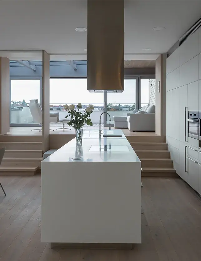 Detailní pohled na kartáčovanou dubovou podlahu z kolekce Oakcent Sand, jejíž přírodní odstín a jemná textura dřeva s přiznanými suky tvoří klidný a sjednocující základ minimalistického interiéru střešního bytu.