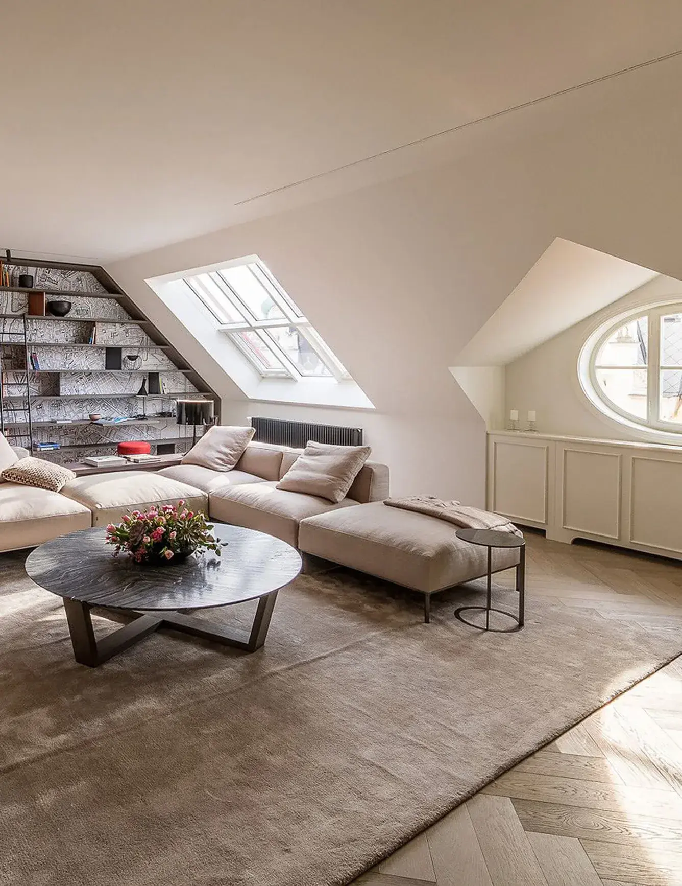 Detailní záběr na kuchyňský ostrůvek s tmavou mramorovou deskou a zlatou vodovodní baterií v pražském podkrovním bytě od Ivanky Kowalski, kde dubová podlaha Oakcent Premium Herringbone v odstínu Quartzgrau plynule přechází do obývací části s výhledem na Staré Město.